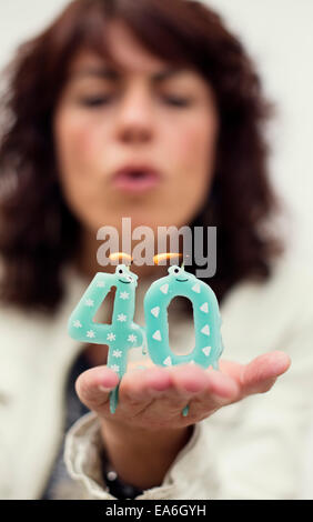 Woman blowing out candles pour 40e anniversaire Banque D'Images