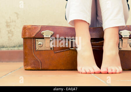 Fille assise sur une valise Banque D'Images