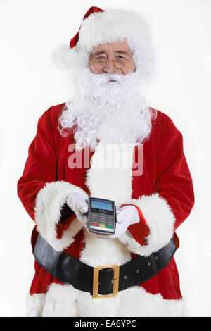 Studio Shot of Santa Claus Holding Credit Card Reader Banque D'Images