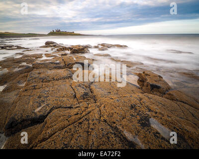 La côte sauvage de l'île sacrée dans le Northumberland est protégé par le Château de Lindisfarne sur une belle morni hivers Banque D'Images