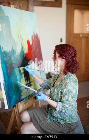 Middle-aged woman holding palette et peinture sur toile Banque D'Images