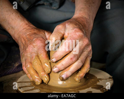 Mains d'un potier, la création d'un pot en terre sur le cercle Banque D'Images