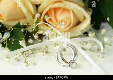 L'engagement et les anneaux de mariage avec bouquet de fleurs Banque D'Images