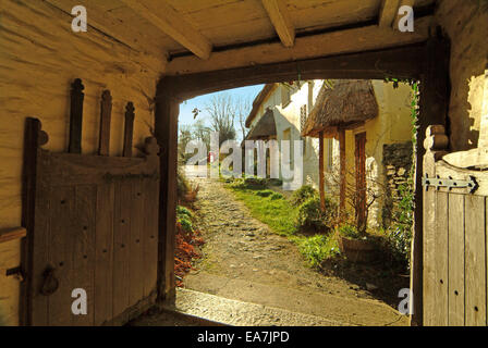 Archway avec porte en bois ouverte menant hors de l'église le long du chemin au-delà de la ligne de chaumières St Clement près de Truro Malpas Banque D'Images