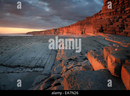 Nash Point sur la côte du Glamorgan au coucher du soleil, avec la lumière du soir rougeoyant sur les falaises et rochers Banque D'Images