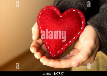 Coeur rouge dans les mains de l'enfant, cadeau, fait main valentine, Close up, horizontal Banque D'Images