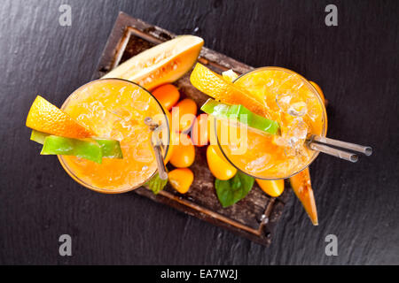 Orange douce,cocktails aux fruits exotiques, servi sur la surface de la pierre noire Banque D'Images