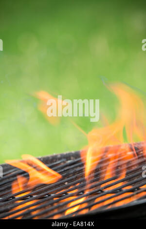 Grille vide sur jardin avec burning embers Banque D'Images