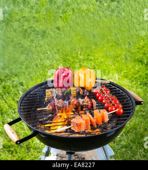 La viande et de légumes sur la grille du barbecue à feu Banque D'Images