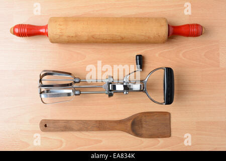 Trois anciens et utilisés pour le four, robot, rouleau à pâtisserie, sur une spatule en bois et table de cuisine en bois. High angle shot horizontale en fo Banque D'Images