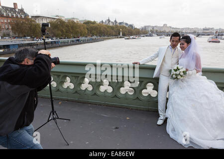 Un couple chinois ont les photographies de mariage prises par la Tamise à Londres, Angleterre, RU Banque D'Images