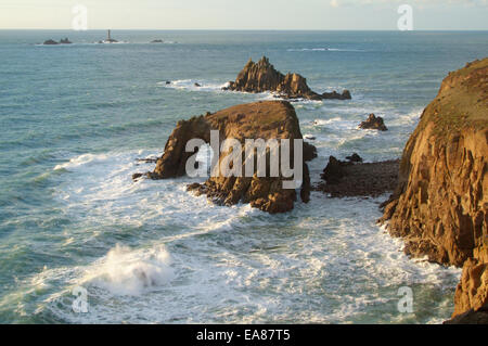 Vue sur Zawn puits aux îles rocheuses de Enys et Dodnan Le chevalier armé avec Phare drakkars dans distance Lands End Banque D'Images