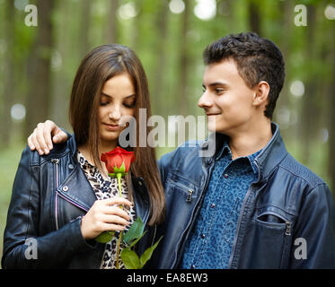 Teenage angst - un garçon donnant une fleur à son amie, dans le parc de plein air Banque D'Images