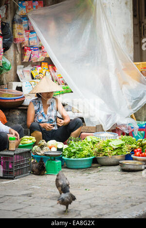 Femme vendant des fruits et légumes frais au marché Dong Xuan dans la vieille ville d'Hanoi Banque D'Images