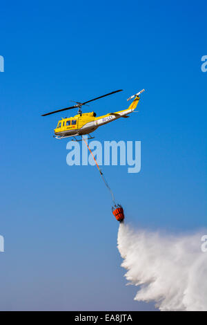 Travailler sur fire suppression d'un hélicoptère de l'eau à charge le Lowveld Air Show Banque D'Images