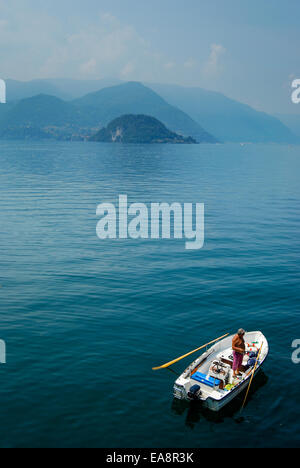 L'homme de pêche bateau à rames près de Bellagio sur le lac de Côme en Italie du nord Banque D'Images