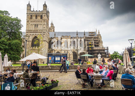 Cathédrale d'Exeter et à proximité de la cathédrale avec des gens assis et de manger sur la rue pavée près en face de la cathédrale. Fondée 1050 Banque D'Images