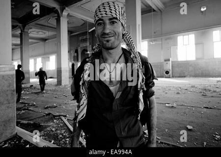 Membre de l'Office de sécurité syriaque communément appelé le Sutoro Sutoro ou la police une force de police, Christian assyrien portant un collier croix posant pour l'appareil photo à l'intérieur d'un sanctuaire soufi de Cheikh Khaznawi détruits par ISIS ou d'ISIL dans tel Marouf ou Grand Maruf village de Al Hasakah ou Hassakeh district dans le nord-est de la Syrie Banque D'Images