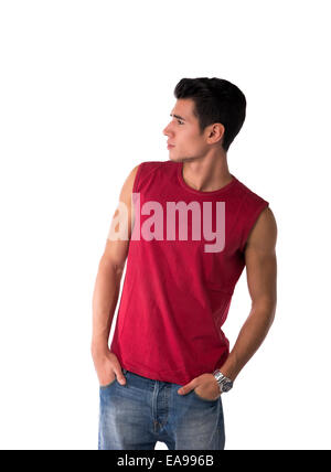 Beau jeune homme en rouge T-shirt et jeans, à la recherche d'un côté à l'espace vide à côté de lui, isolated on white Banque D'Images