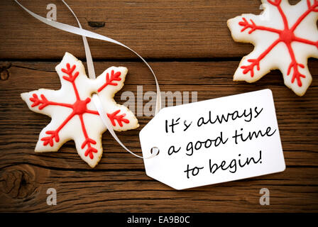 Red Christmas Stars Cookie avec étiquette blanche avec la vie citation disant que c'est toujours un bon moment pour commencer sur fond de bois Banque D'Images