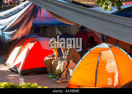 Les manifestants réclament des mesures sur les 43 élèves croyaient disparues exécutés par des policiers corrompus prendre une pause dans leur camp occupant la place principale, le 8 novembre 2014 à Oaxaca, au Mexique. Les 43 élèves absent pendant plus de six semaines sont présumée morte après des restes humains calcinés ont été pêché d'une rivière et ses rives le 7 novembre 2014. Banque D'Images