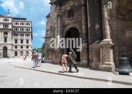 Une femme se frotte les mains de la statue assise en bronze sur la place et l'église de Saint François d'assise Banque D'Images