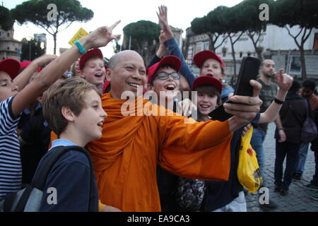 Rome, Italie 9 Novembre 2014 - Le moine bouddhiste de parler une photographie avec les selfies groupe d'enfants sur la Via dei Fori Imperiali street à Rome Italie Crédit : Gari Wyn Williams/Alamy Live News Banque D'Images