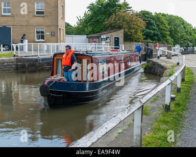 Un petit bateau entre dans le haut de la montée 5 écluses sur le canal à Liverpool et Leeds West Yorkshire Bingley Banque D'Images