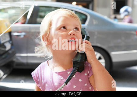 Portrait plein air de petite fille blonde Woman talking on the street phone Banque D'Images