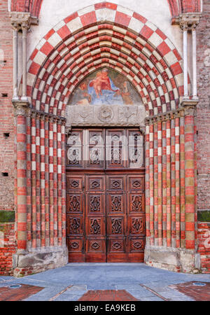 Old vintage porte de bois à l'entrée de l'église catholique à Alba, Italie (composition verticale). Banque D'Images