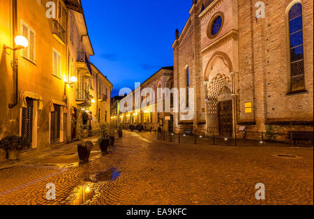 Rue Pavée, entre l'ancienne église et maisons de lampadaires tôt le matin dans l'Alba, l'Italie. Banque D'Images