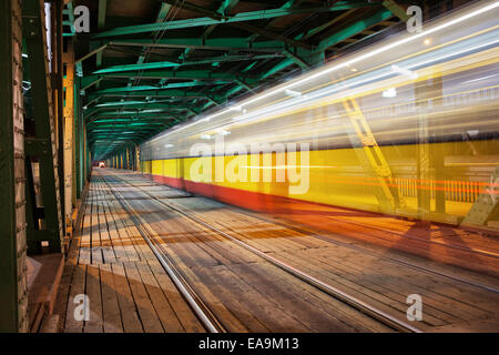 Sentier de lumière tramway dans la partie inférieure de la charpente en acier Gdanski Bridge à Varsovie, Pologne, vanishing point de vue. Banque D'Images