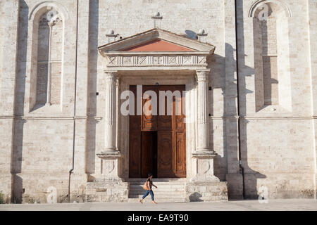 Femme en passant devant l'église de San Pietro Martire, Ascoli Piceno, Marches, Italie Banque D'Images