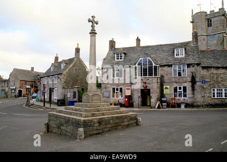 Le centre du village avec croix et l'église à Corfe Castle, Dorset, England, UK. Banque D'Images