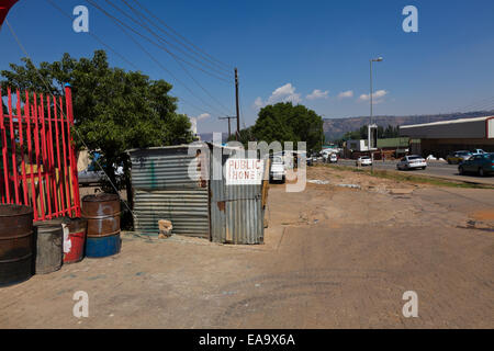 Le Lesotho. La fracture numérique. Téléphone public accessible en milieu rural au Lesotho située dans une cabane en tôle ondulée sur la route principale. Banque D'Images