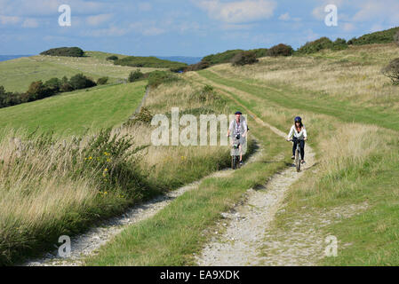 Un jeune couple à vélo le long de la South Downs Way à Butts Brow, Willingdon, près de Eastbourne, East Sussex. UK Banque D'Images
