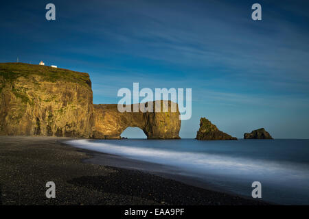 Vagues se brisant sur le rivage avec Dyrholaey dans l'arrière-plan, de l'Islande. Dyrholaey traduit signifie "le trou de la porte" Banque D'Images