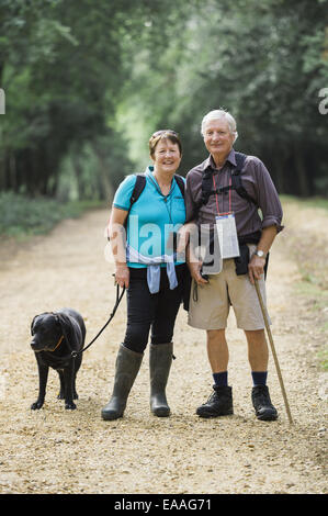 A mature couple hiking avec leur chien. Banque D'Images