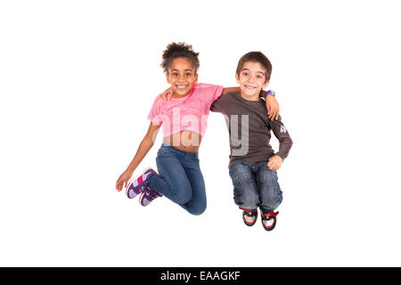 Couple d'enfants isolés saut en blanc Banque D'Images