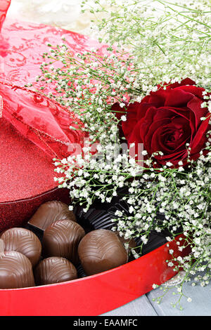 Boîte en forme de coeur de la Saint Valentin chocolats avec de belles roses rouges tige longue. Banque D'Images