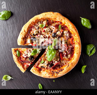 Frais fait maison pizza italienne avec légumes. Servi sur la surface de la pierre noire. Tourné à partir de la vue supérieure Banque D'Images