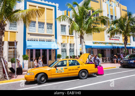 Miami Beach Florida,Ocean Drive,Ocean Five,hôtel,hôtel,hôtels,taxi,jaune,chauffeur,mettre les bagages dans le coffre,FL140823001 Banque D'Images