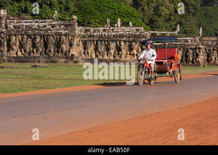 Cambodge, Angkor Thom. Taxi moto en passant la Terrasse des éléphants. Banque D'Images