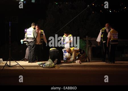 Bethléem. 10 Nov, 2014. Les médecins israéliens et les membres des services religieux chercher des traces de sang alors qu'ils nettoyer la scène à un arrêt de bus près de la colonie juive d'Alon Shvut près de la ville cisjordanienne de Bethléem, où une femme juive aurait été poignardé à mort par un Palestinien, le 10 novembre 2014. L'agresseur présumé, un Palestinien dans la trentaine identifiés comme Maher al-Hashlamun, aurait tenté de jeter son véhicule vers un arrêt de bus et puis a commencé à poignarder les gens. Il aurait été blessé par un garde de sécurité sur les lieux. Credit : Luay Sababa/Xinhua/Alamy Live News Banque D'Images