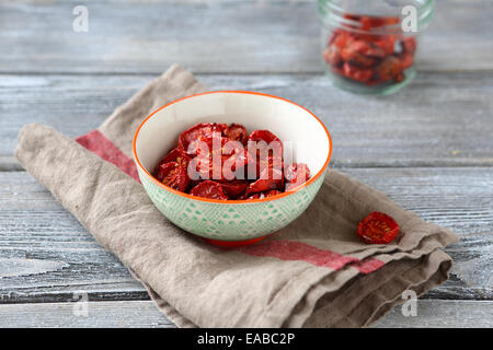 Tomates cerises séchées dans un bol, fond de bois Banque D'Images