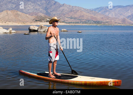 Un homme âgé sur le stand sur paddle boards sur le lac Isabella près de Bakersfield, à l'Est de la vallée centrale de la Californie qui est à l Banque D'Images