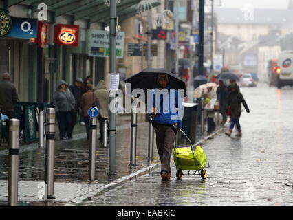 Swansea, Royaume-Uni. 11 novembre, 2014. Météo britannique. Ces consommateurs parapluies dans Oxford Street, Swansea, Pays de Galles du sud. Re : pluie sévère ont été touchant et alerte d'inondations ont été prévues pour certaines régions du sud et l'ouest du pays de Galles. Credit : D Legakis/Alamy Live News Banque D'Images