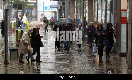 Swansea, Royaume-Uni. 11 novembre, 2014. Météo britannique. Ces consommateurs parapluies dans Oxford Street, Swansea, Pays de Galles du sud. Re : pluie sévère ont été touchant et alerte d'inondations ont été prévues pour certaines régions du sud et l'ouest du pays de Galles. Credit : D Legakis/Alamy Live News Banque D'Images