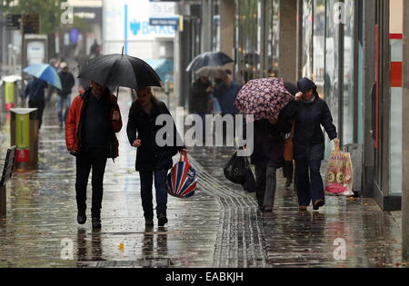 Swansea, Royaume-Uni. 11 novembre, 2014. Météo britannique. Ces consommateurs parapluies dans Oxford Street, Swansea, Pays de Galles du sud. Re : pluie sévère ont été touchant et alerte d'inondations ont été prévues pour certaines régions du sud et l'ouest du pays de Galles. Credit : D Legakis/Alamy Live News Banque D'Images