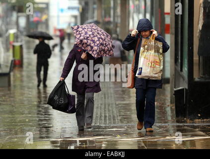 Swansea, Royaume-Uni. 11 novembre, 2014. Météo britannique. Ces consommateurs parapluies dans Oxford Street, Swansea, Pays de Galles du sud. Re : pluie sévère ont été touchant et alerte d'inondations ont été prévues pour certaines régions du sud et l'ouest du pays de Galles. Credit : D Legakis/Alamy Live News Banque D'Images